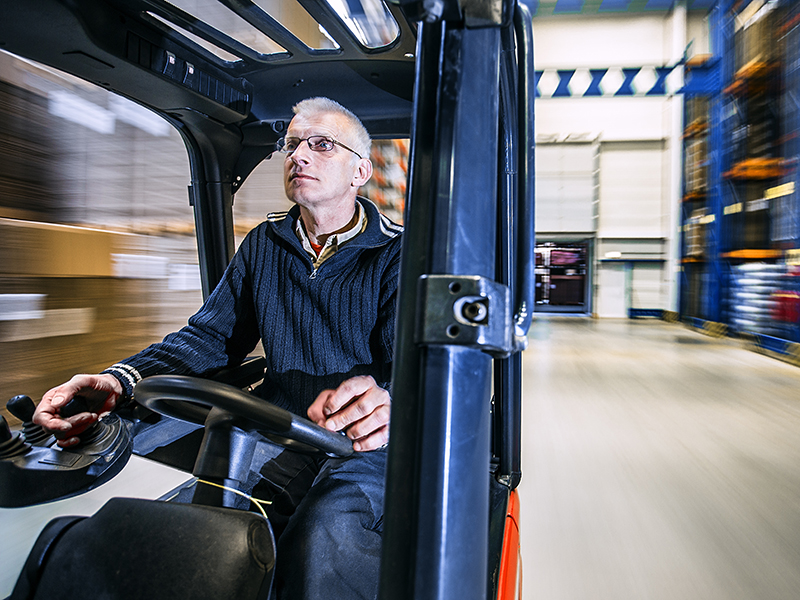 Truckförare kör en truck på ett lager