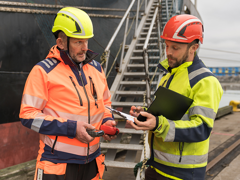 En hamnarbetare instruerar en annan.