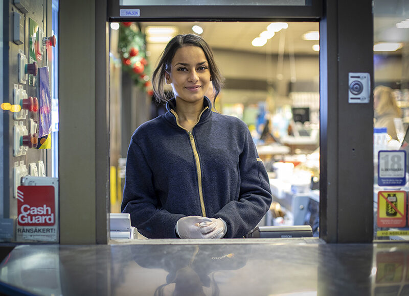 Ung kvinna i nattlucka på drivmedelsstation
